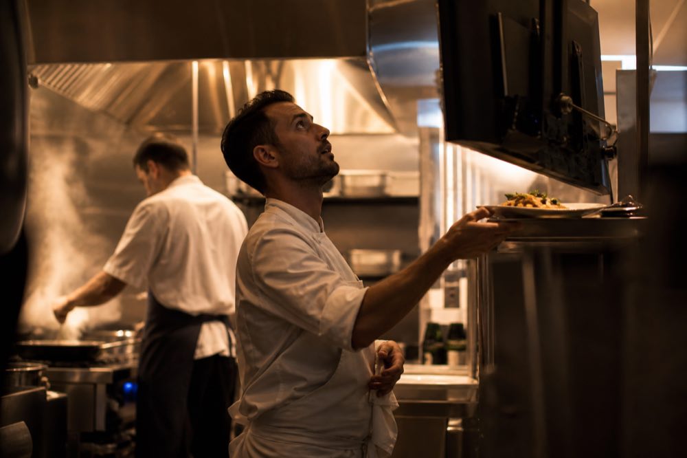 Cozinheiro conferindo o pedido na tela da cozinha